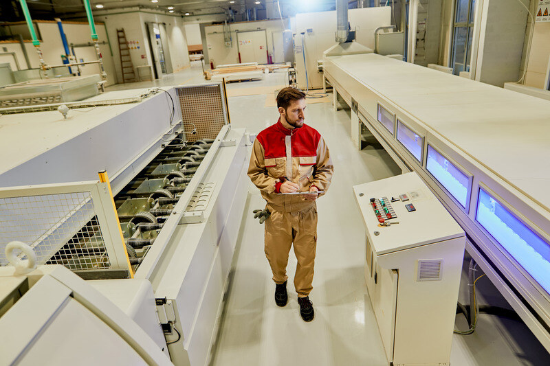 industrial-worker-supervising-automated-machines-while-walking-through-woodworking-factory (1)
